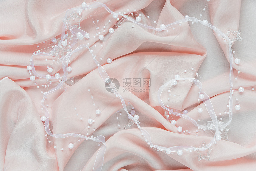温柔的粉色卷状白丝带和珍珠的婚礼背景图片