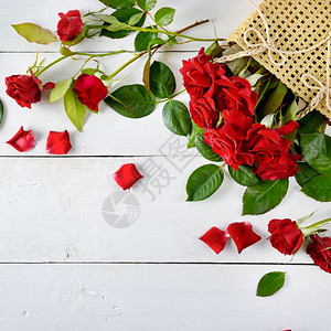 白木背景上的红玫瑰平躺顶部视图图片