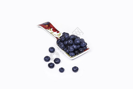 浅色背景上有一勺大蓝莓的瓷子图片