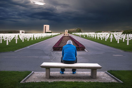 军事坟墓坐在长凳上的人思考着所有士兵们通过这个美国纪念背景