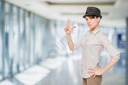穿黑帽子的女人在办公室里拿着手指背景图片