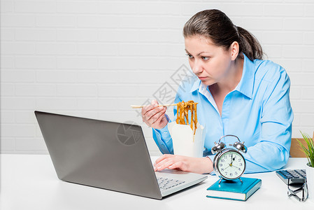 女会计在午餐休息时吃面在笔记本电脑上工作女商人高清图片素材