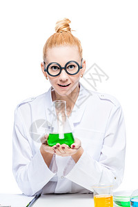 金发美女戴着圆滑的眼镜带着绿色液体的灯泡图片