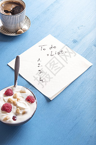 白色餐巾纸和一份待办清单草稿周围是一碗酸奶图片