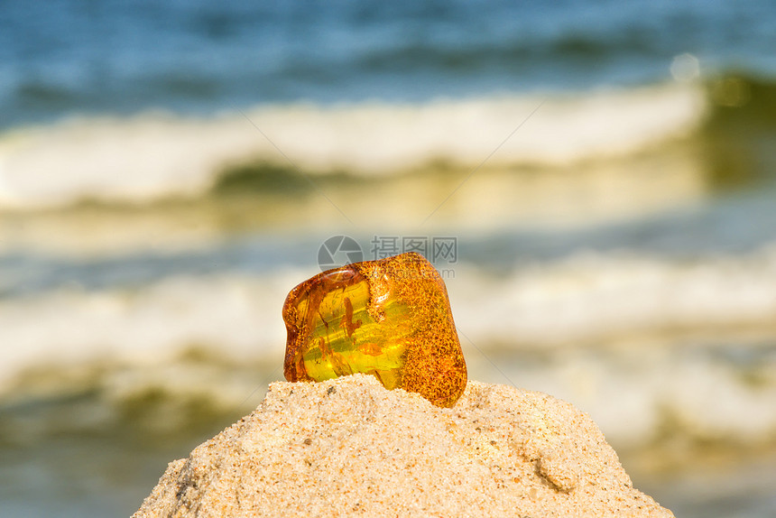 在黄海沙滩上的琥珀在背景中冲浪图片
