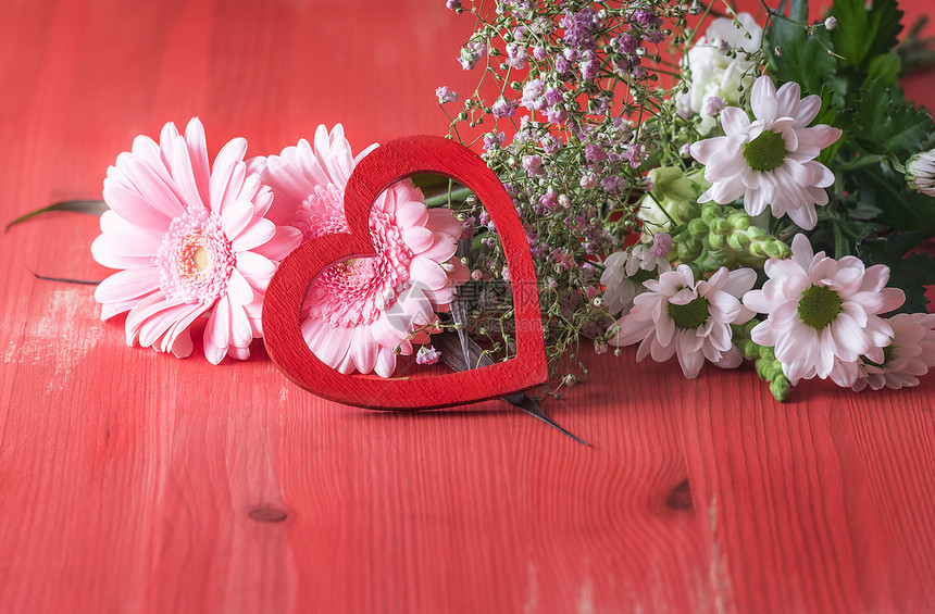 在红色木质背景上展示的浪漫形象与花束朵由不同的菊组成配有装饰的木心附着在树上图片