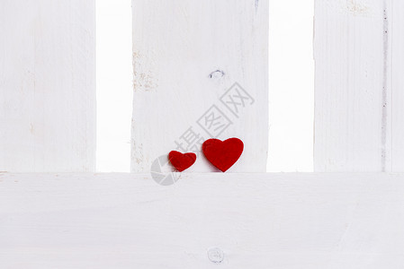 一个大红心的主题关系图像与一个小红心相邻在白色木栅栏上爱的概念伙伴关系团队贺卡的想法背景图片