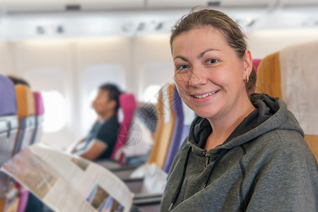 飞机乘客坐在椅子上微笑的看着镜头假日高清图片素材