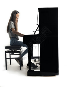 少女在弹奏直立钢琴图片