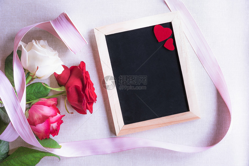 情人节主题图像美丽的玫瑰绑着粉红色的丝带和白黑板装饰着两颗红心图片