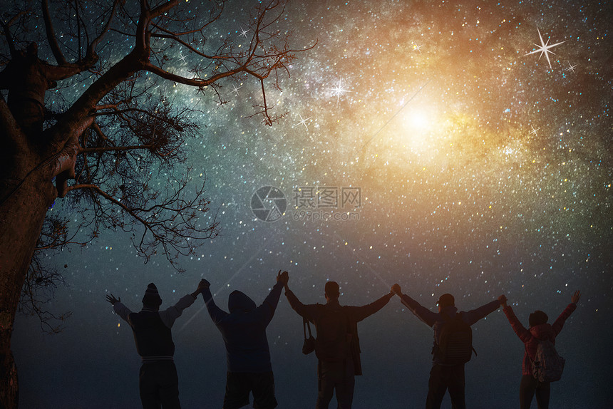 夜晚的天空与星和欢乐的人们一起站立在空中举起手来蓝色的乳白天空与山上人一起与宇宙的背面夜晚光景旅行自由的概念图片