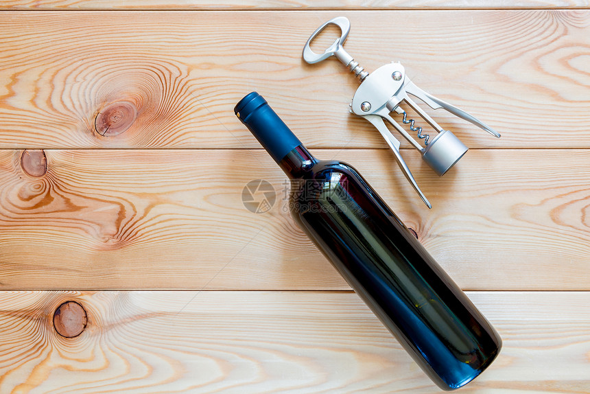 一瓶红酒和木板上的瓶装子顶端视图图片