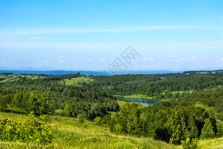 夏季美丽的山地景观包括蓝湖风景优美的山坡观滚动的山丘和天空美丽的景观夏季美丽的山地景观和蓝湖背景图片