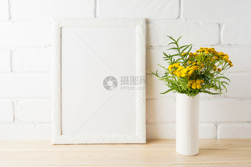 白色框架绿的花朵画砖墙附近的花朵空白框架用于演示设计现代艺术的模板白色框架画砖墙附近的黄色花朵图片