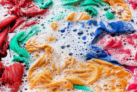 彩色衣服浸泡在水中洗涤粉末中蓝色高清图片素材
