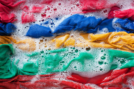 彩色衣服浸泡在水中洗涤粉末中垫圈高清图片素材