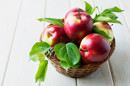 成熟的红苹果夹着绿叶子的篮成熟红苹果夹着绿叶子的篮图片