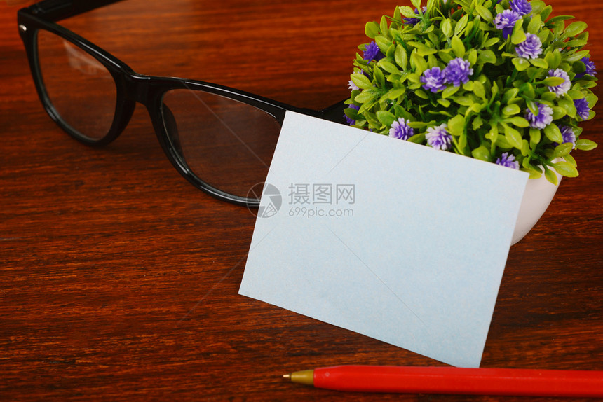 木制办公桌上带笔和眼镜的空白名片图片