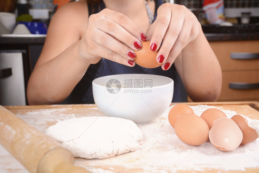 女厨师把鸡蛋打进碗里图片