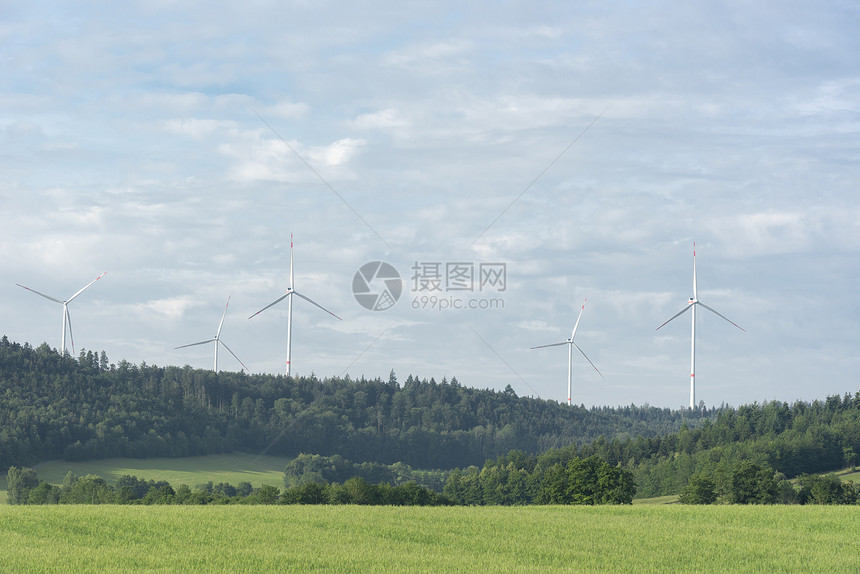 蓝色天空下的森林里靠近德国城市的舒瓦比舍大厅有着几台风力涡轮机图片