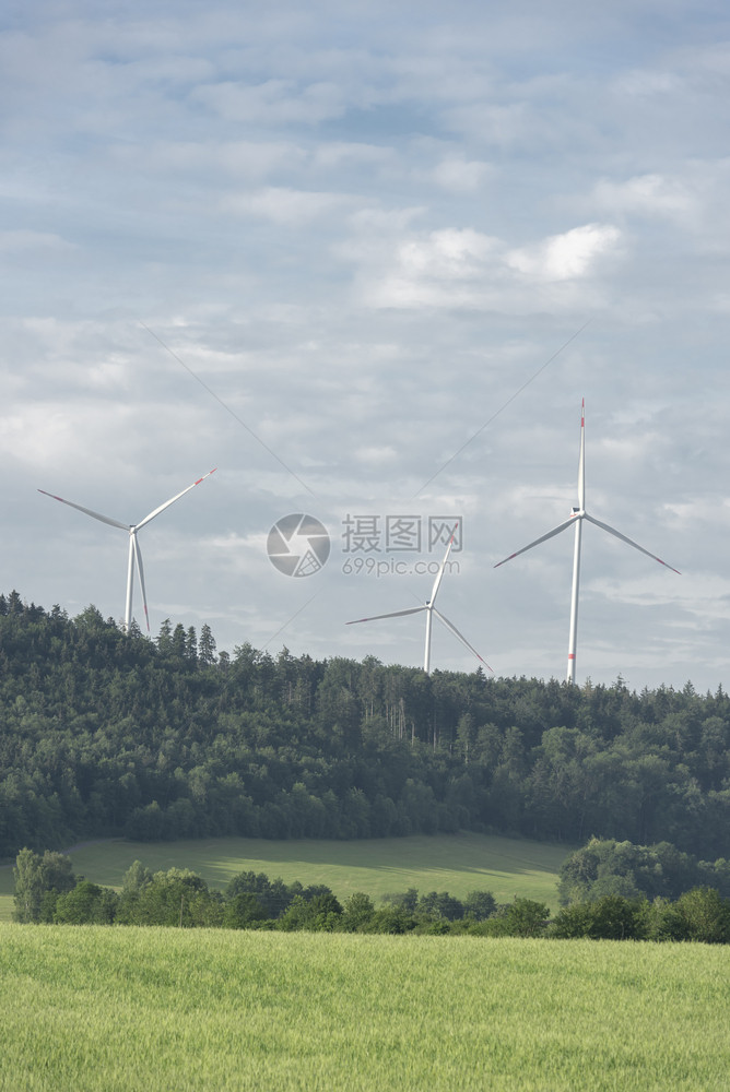在蓝天下德国城市Schwabi大厅附近的森林上空地平线风涡轮机图片