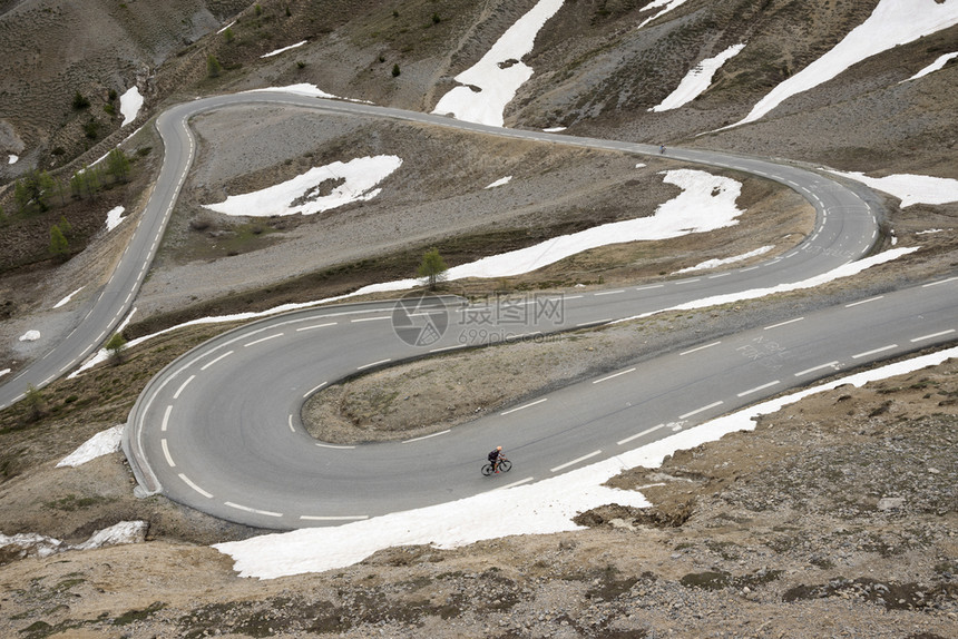 骑自行车的孤单男子几乎在法国高地海拔山的coldizar顶端图片