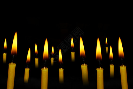 燃烧自己点亮别人黄蜡烛在抽象的黑暗背景上设计图片