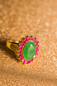 金色绿宝石戒指优雅的女首饰金戒指配有珍贵的绿宝石背景
