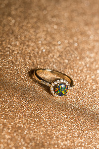 时尚的金环配有绿色的合成火花状石背景图片