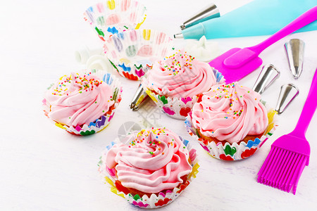 配奶油霜和甜针筒的蛋糕配粉红色奶油的生日蛋糕自制的装饰纸杯蛋糕图片