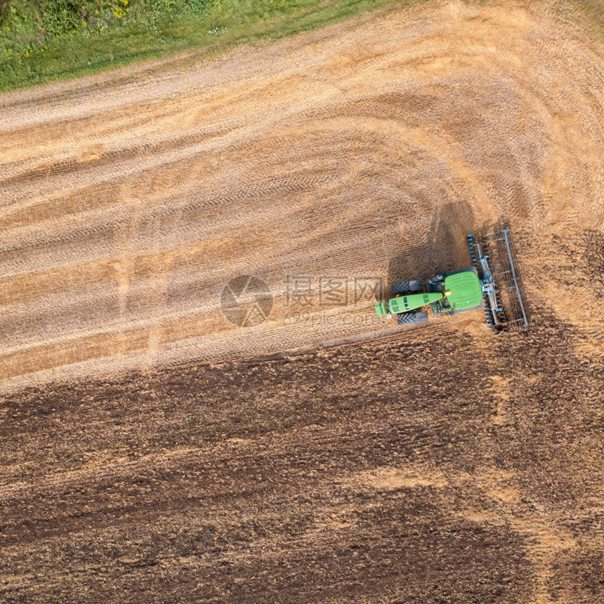 拖拉机在秋天收获田地后耕种拖拉机在田地上耕种图片
