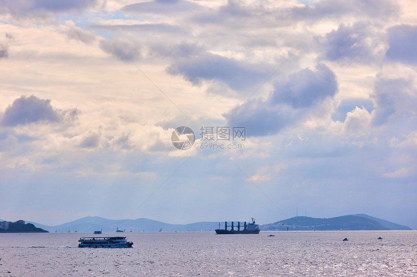 海景宽广船过天空美丽云彩灰白船经过岛湾海图片
