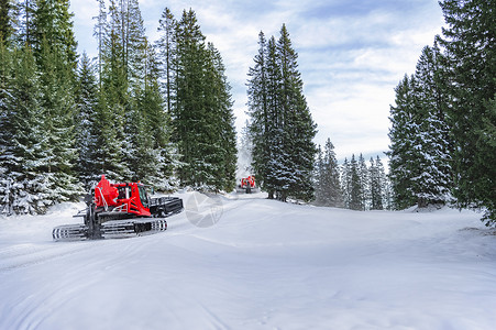 两辆红色雪地车经过大雪山图片