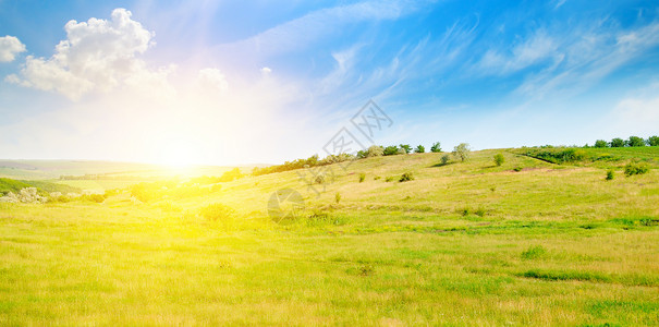 山丘绿地和日出在蓝色的天空农业景观宽广的照片图片