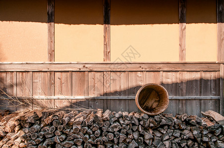 Japn在古村edo镇Bsnmura露天航空博物馆的老古小屋堆成的木柴和桶背景图片