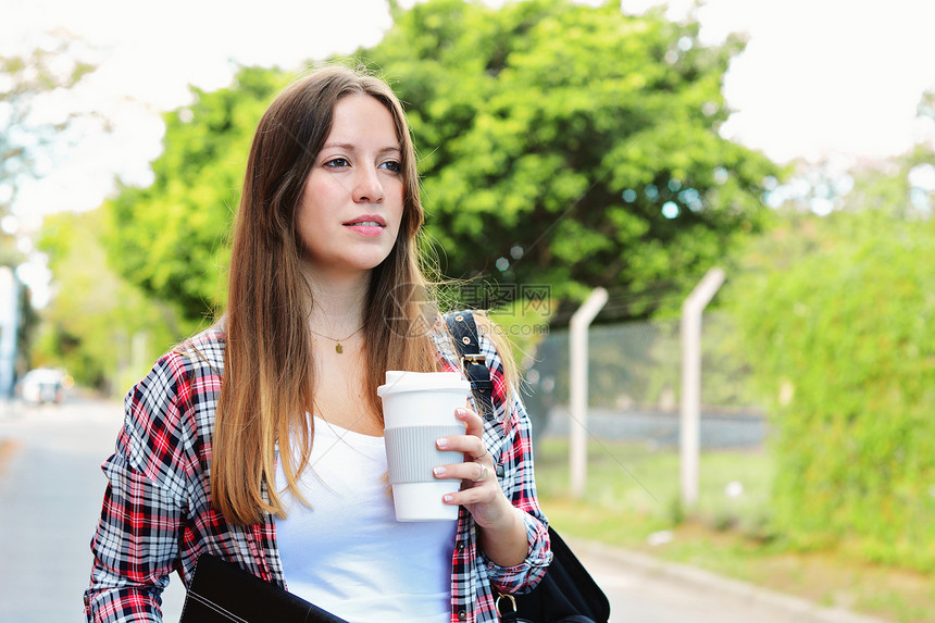 在街上拿着纸咖啡杯的美女肖像城市的风景户外图片