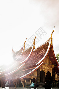 老挝琅勃拉邦阳光下的老挝风格寺庙屋顶图片