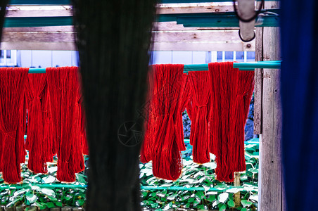传统丝绸或棉花织物纺品红色天然染线关闭纹理细节图片