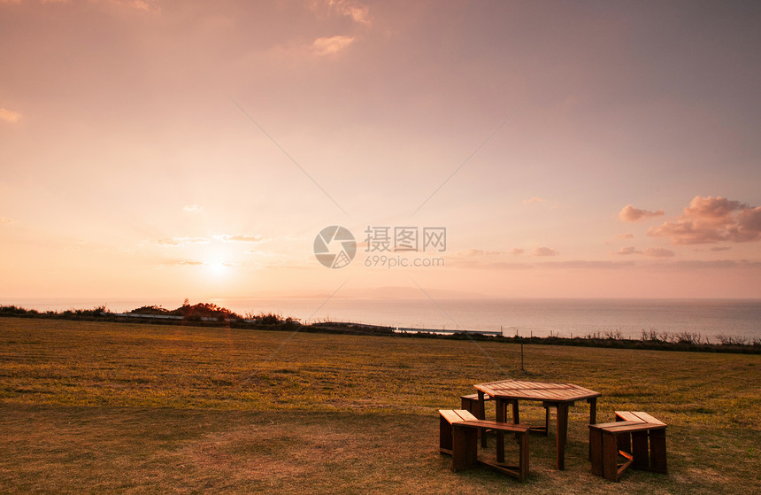 日落或出时在本霍基那瓦岛的Ishigak岛野餐桌下在海边宽阔的草地海野餐桌图片