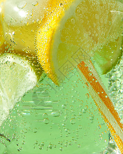 玻璃瓶中气泡玻璃罐中闪亮的新鲜柠檬和片薄荷叶绿色背景的空气泡沫图片