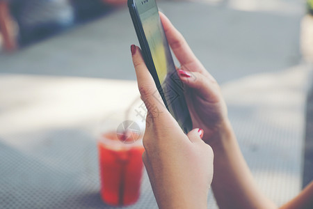 在户外咖啡店网上拥有智能手机交易股的女商业概念贸易高清图片素材