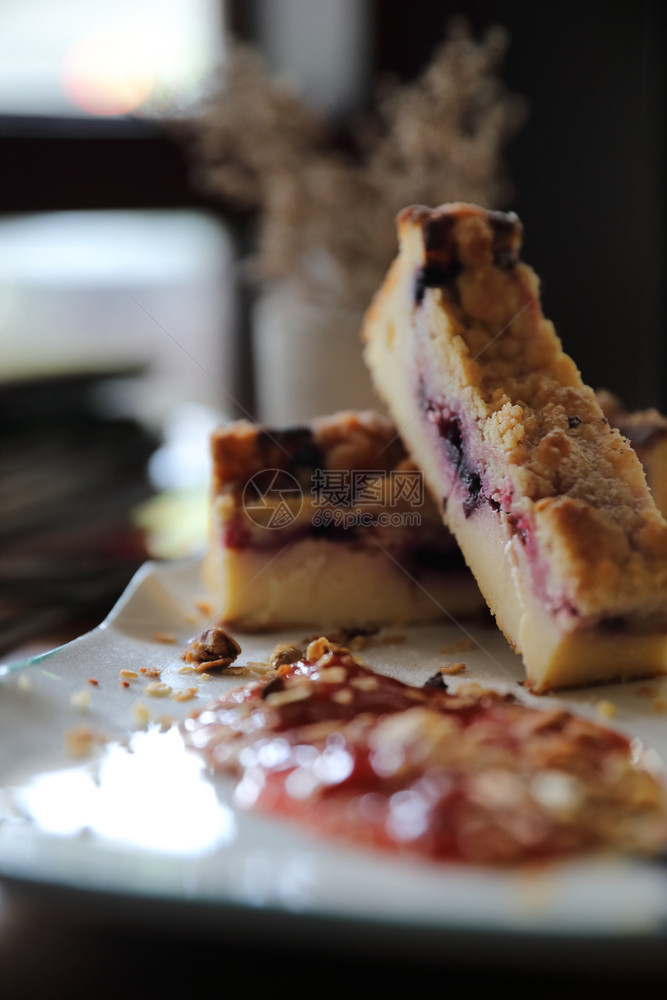 甜点蓝莓奶酪蛋糕在木桌背景上加草莓果酱图片