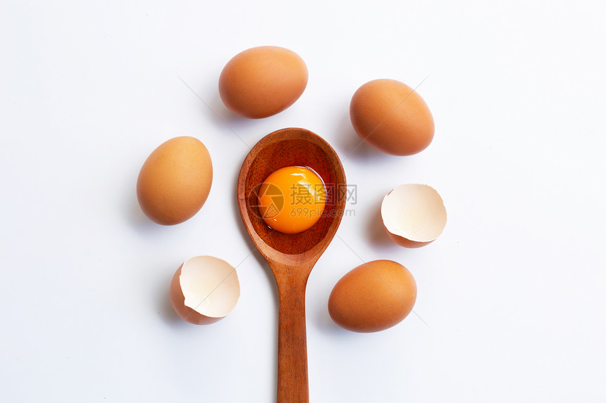 勺子上的蛋黄和旁边的四个鸡蛋图片