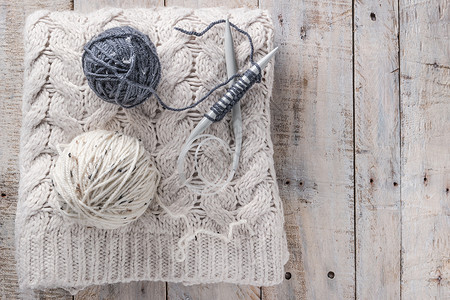 旧针头和木天然羊毛编织背景上的缝线图片