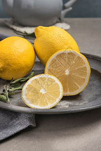 新鲜柠檬和叶在生锈盘上新鲜柑橘水果背景图片