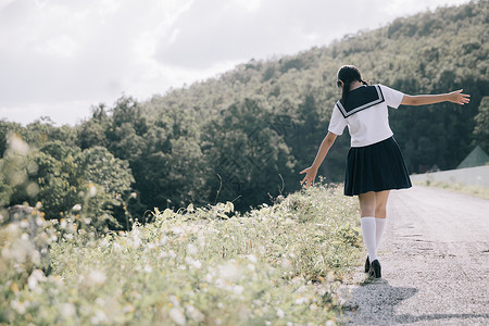 在公园户外电影陈年风格上行走的女学生服装肖像姿势高清图片素材