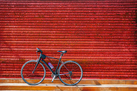 旧仓库红色锈墙对面停车的自行图片