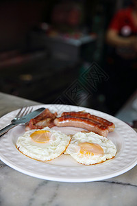 圆白盘上的煎鸡蛋和香肠培根图片