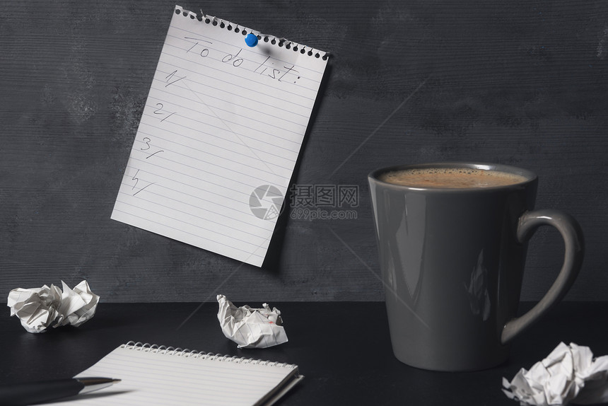 办公桌有空白笔记本折叠页咖啡和挂在墙上的待办事项清单任务组织概念图片