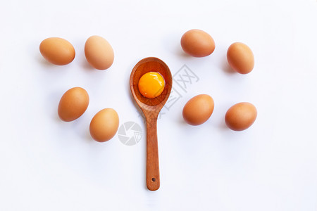 勺子上的蛋黄和旁边八颗完整的鸡蛋图片